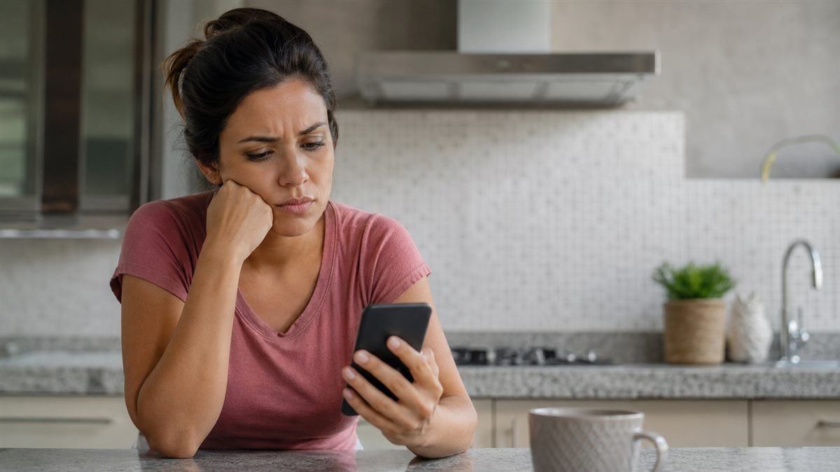 Mãe conferindo a conta e vendo que a pensão não caiu