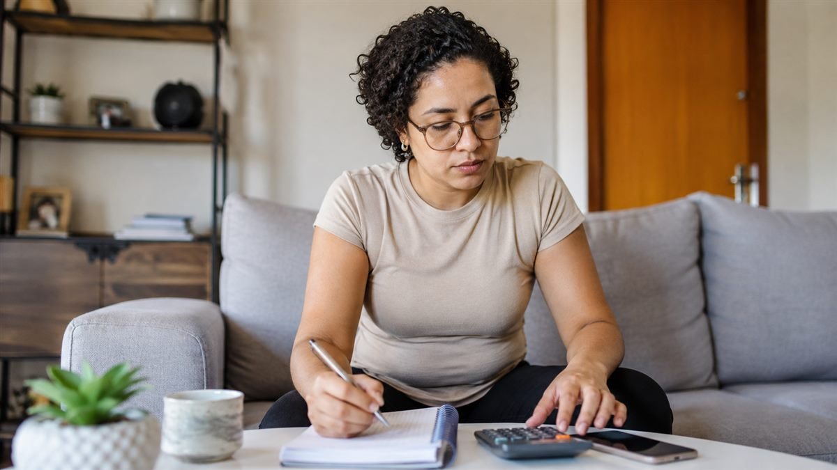 Mãe calculando quanto custa o sustento mensal do filho
