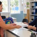 Mãe entregando a certidão de nascimento para matricular o filho na escola